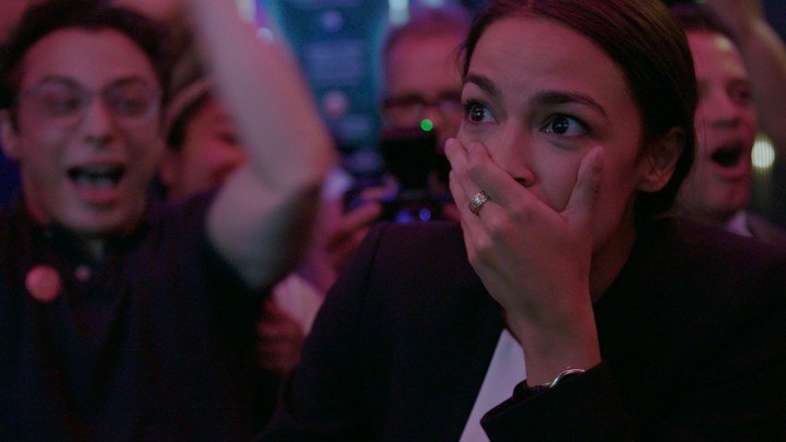 Alexandria Ocasio-Cortez standing in a bar and looking surprised as she won the Primary - Netflix Original Movies of 2019 