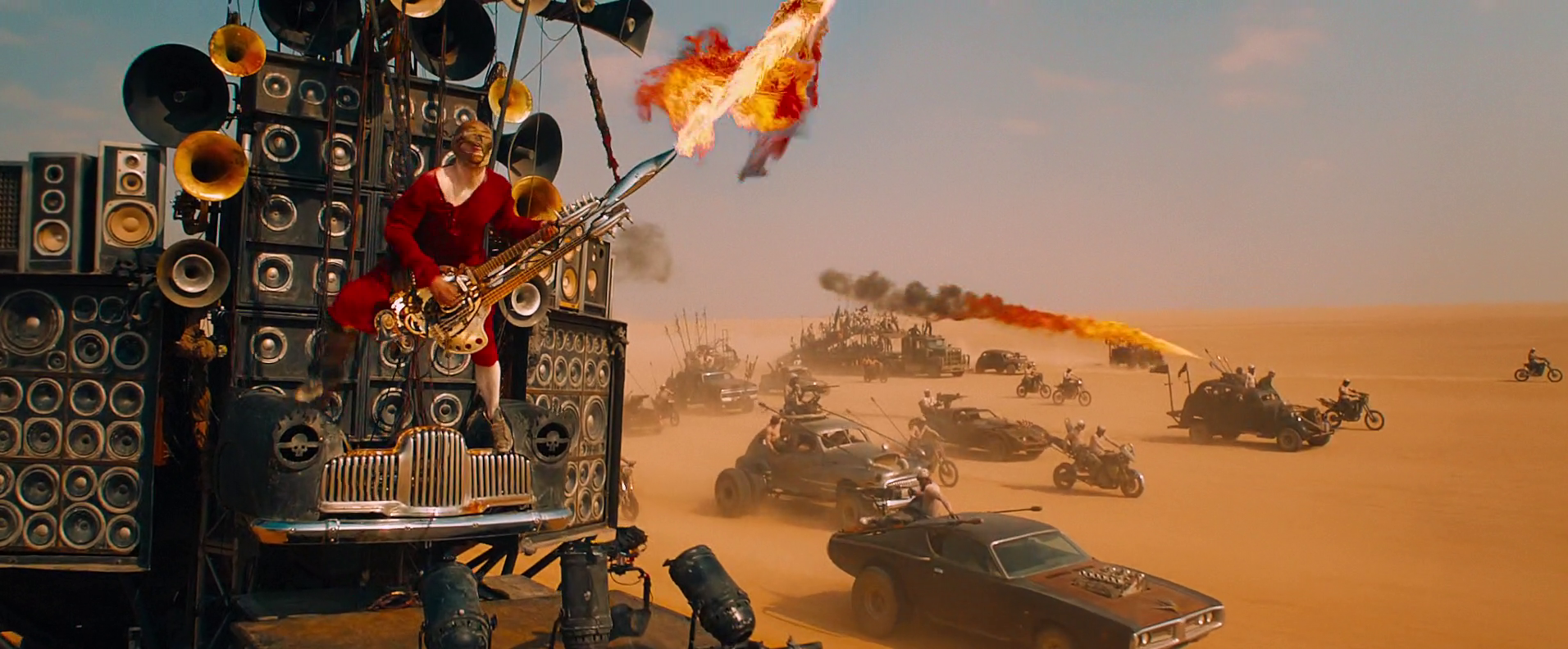 Immortan Joe's "drummer boy," the Doof Warrior (iOTA) is equipped with a double-necked guitar with an integral flamethrower (