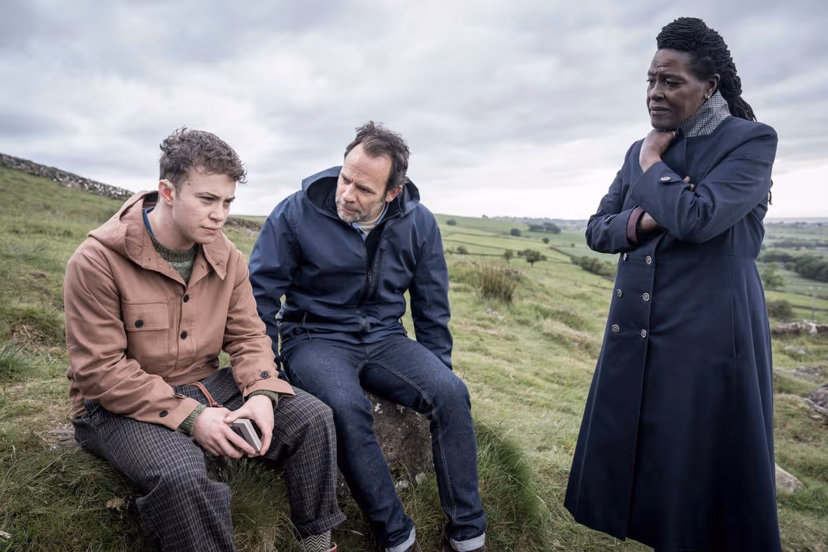 Sharon D Clarke as DCI Ellis with Andrew Gower as DS Harper speaking with a young man on a hillside in Ellis season 2