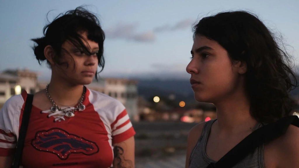 Two young women face each other outdoors at twilight in a scene from Valentina Maurel's film Forever Your Maternal Animal.