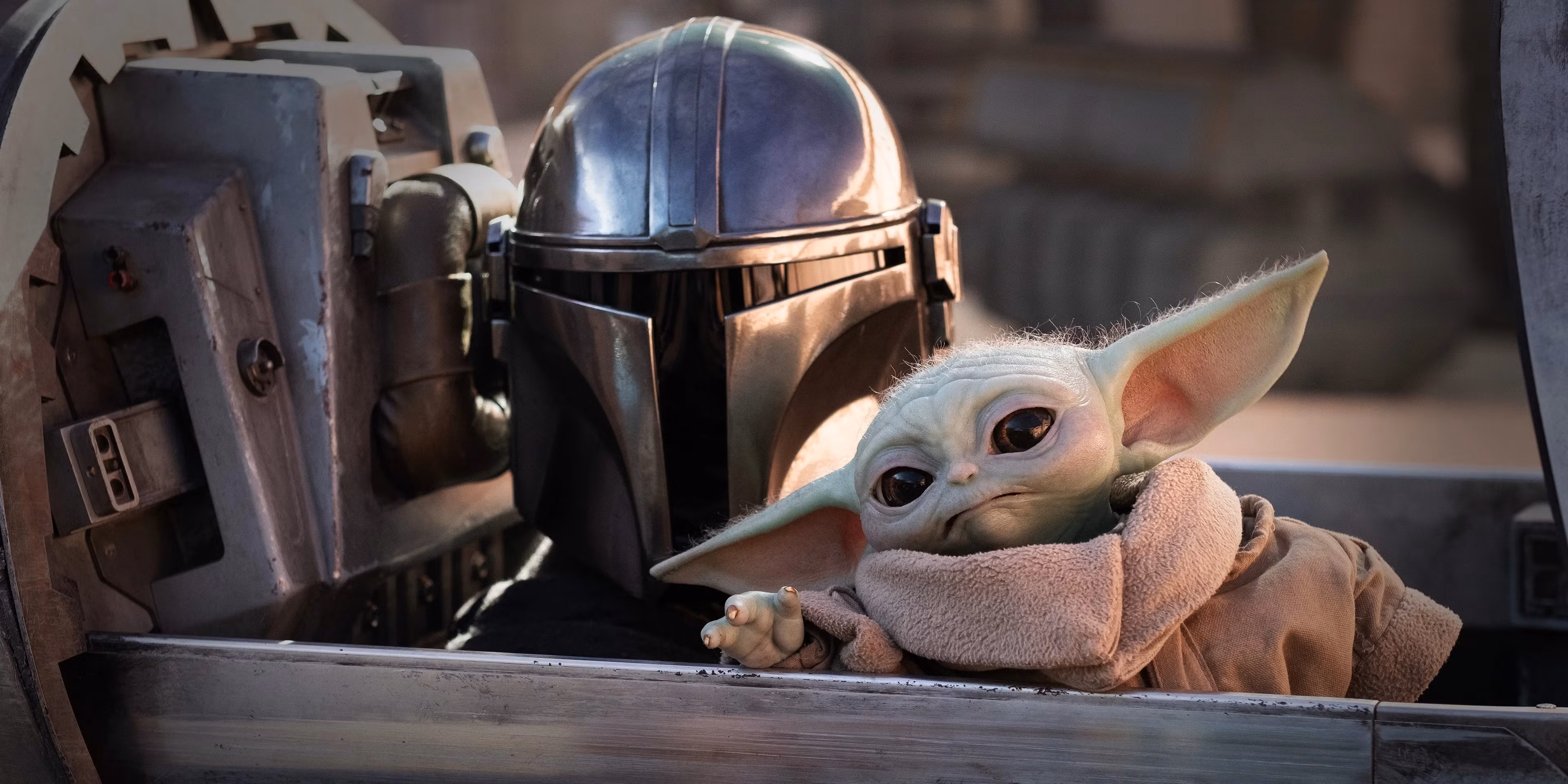 The Mandalorian and Grogu seated together in the cockpit of their starship.